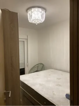 View from the hallway into a bedroom with a bed and a chandelier. - image 5