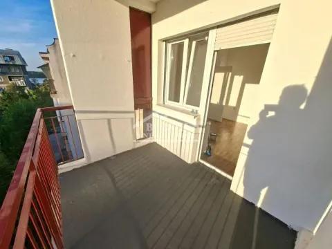 Nenamešten balkon sa crvenom ogradom i pogledom na okolinu. - image 4