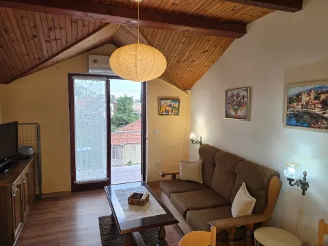 Dnevna soba sa garniturom, drvenim plafonom i izlazom na terasu. - image 5