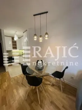 Dining area with a glass table and chairs, connected to the kitchen. - image 9