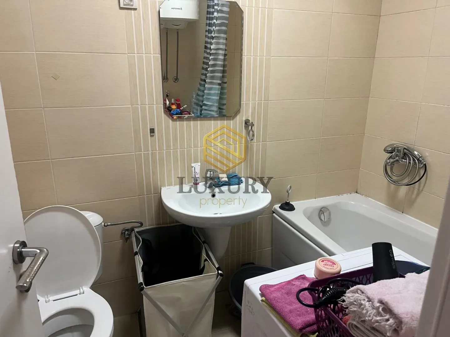 Manje kupatilo sa umivaonikom, kadom i wc šoljom.