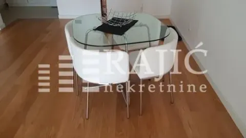 Dining area with a glass table and white chairs. - image 6