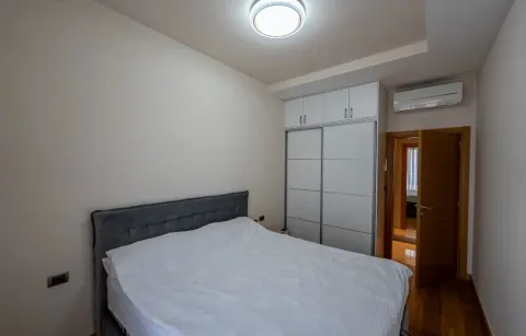 Furnished bedroom with a double bed, built-in wardrobe, and air conditioning. - image 10