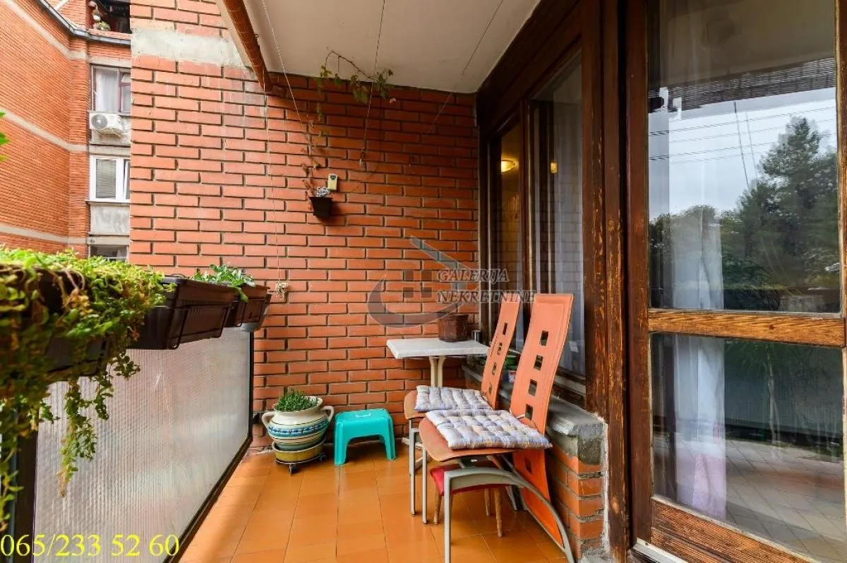 Small balcony with brick wall detail and seating furniture.