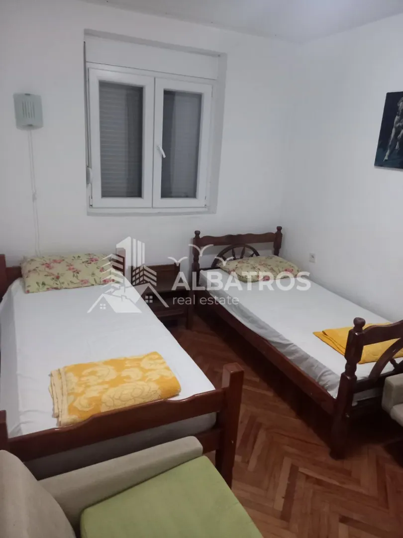Bedroom with two wooden beds and a window.
