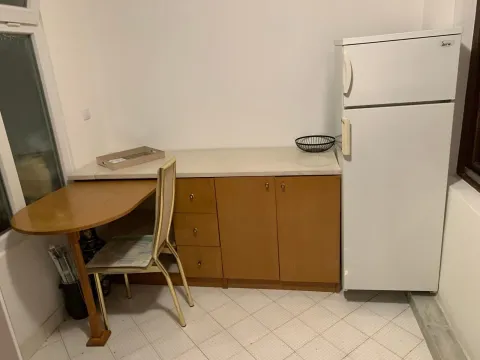 Manja kuhinja sa drvenim elementima, trpezarijskim stolom i frižiderom. - image 8