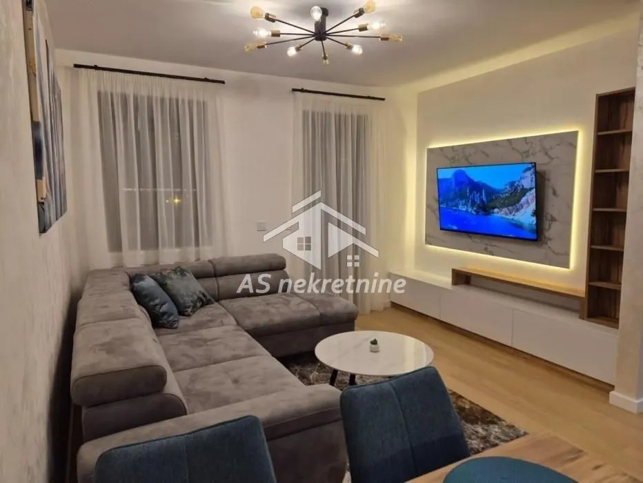Comfortable living room with a sectional sofa and a wall-mounted TV.