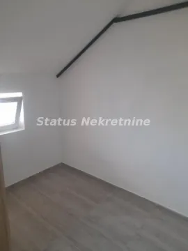 Prazna prostorija u potkrovlju sa belim zidovima, pločicama na podu i manjim prozorom. - image 7