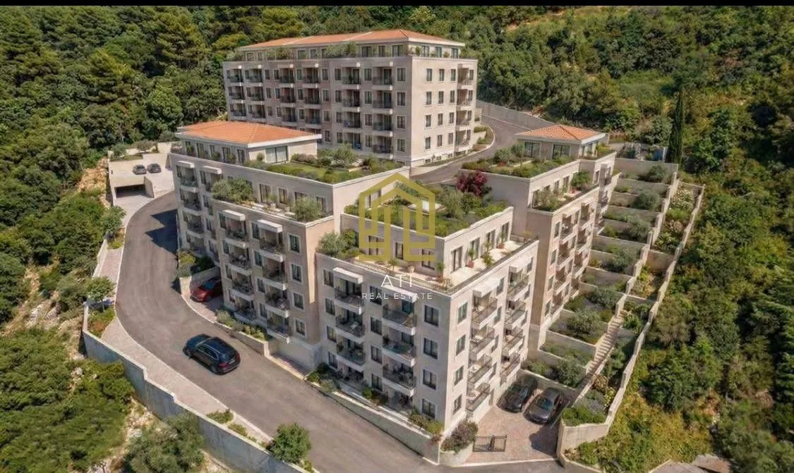 Pogled iz vazduha na moderne stambene zgrade sa uređenim terasama i zelenilom.