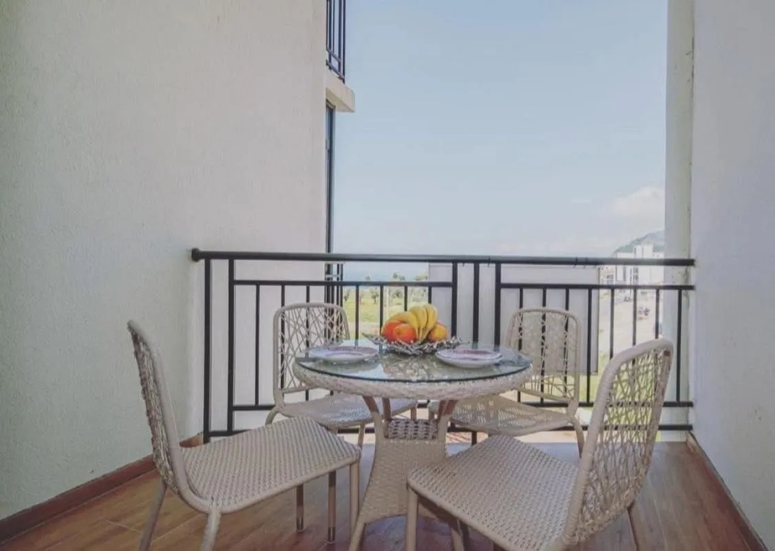 Furnished balcony with a table, chairs, and a sea view.