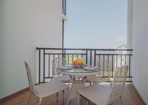 Furnished balcony with a table, chairs, and a sea view. - image 2