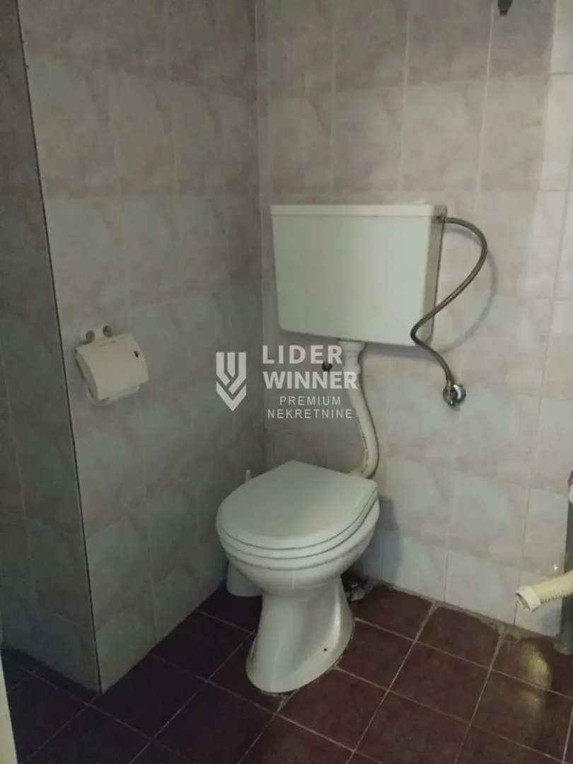 A view of the bathroom with a toilet and ceramic tiles.