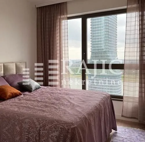 Bedroom with a double bed and a large window with a city view.