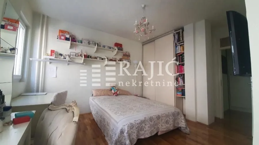 Furnished bedroom with a double bed, wardrobe, and desk.