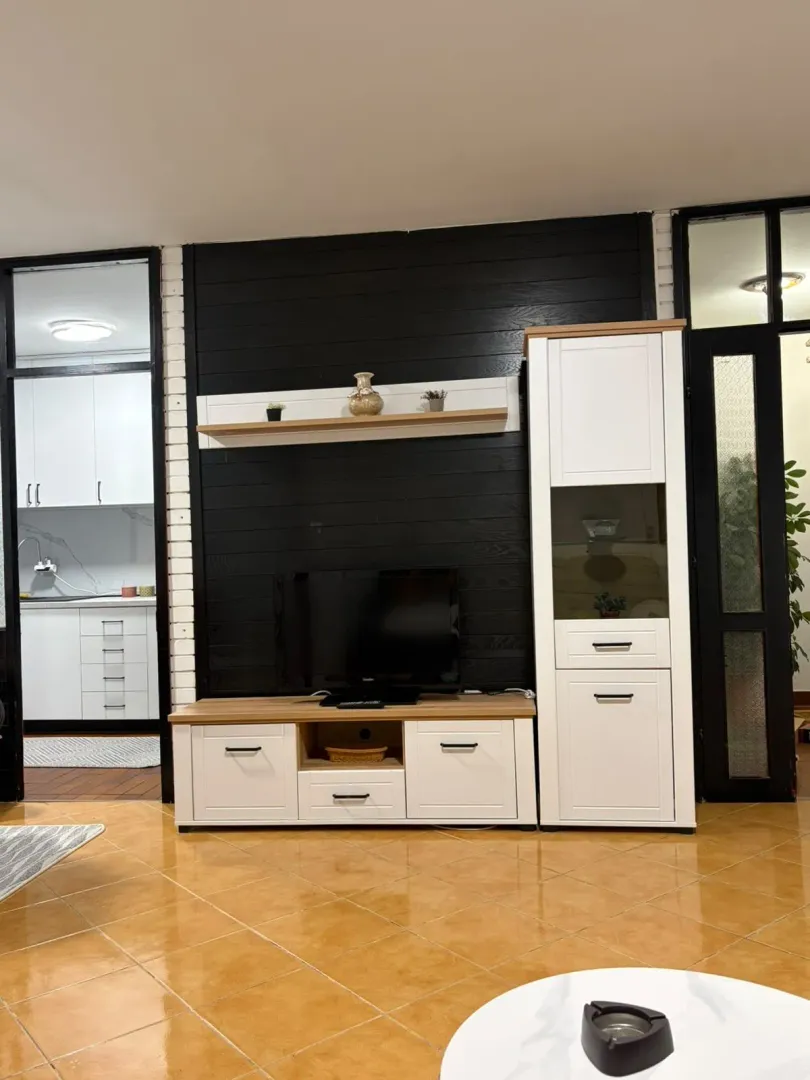 Living room with a TV stand and a black decorative wall panel.
