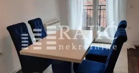 Dining area with a table and blue upholstered chairs. - image 4