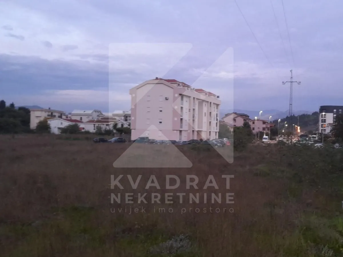 Pogled na zgradu i okolno zemljište u sumrak.