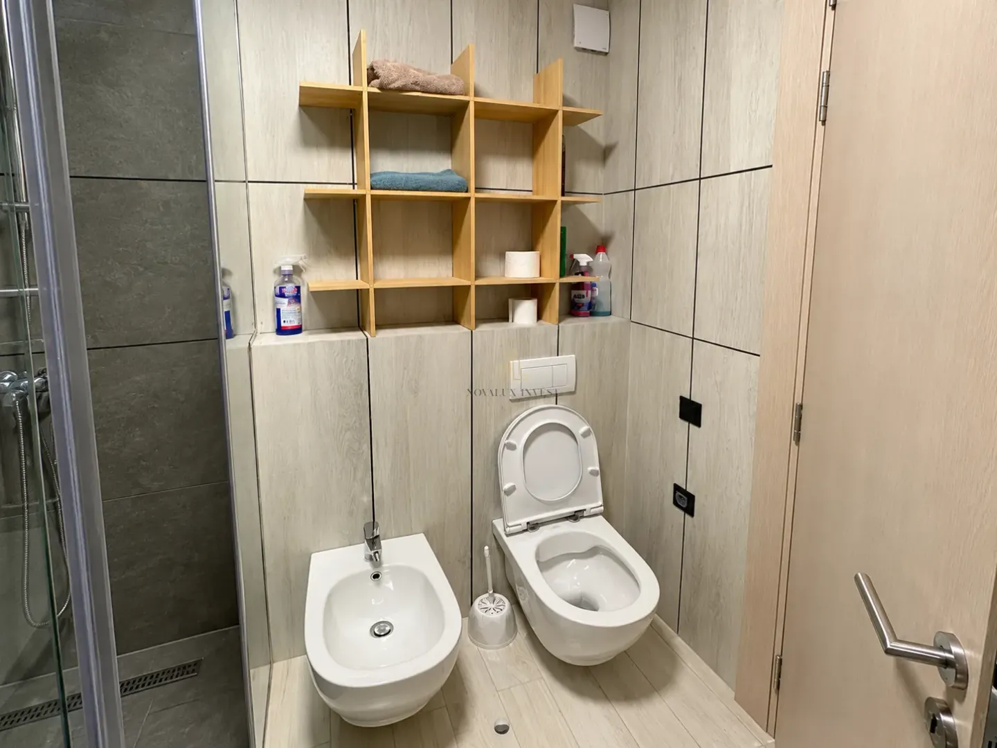 Modern bathroom equipped with a shower cabin, toilet, and bidet.
