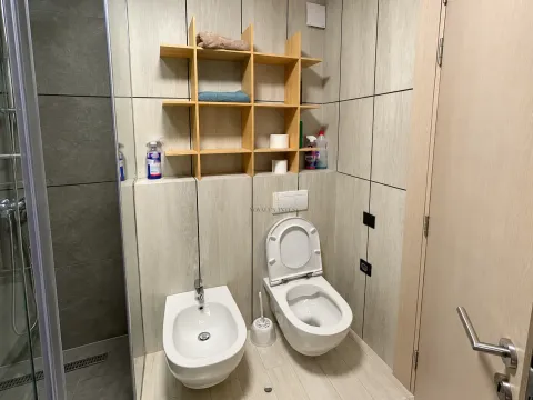 Modern bathroom equipped with a shower cabin, toilet, and bidet. - image 9
