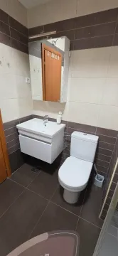 Kupatilo opremljeno umivaonikom, WC šoljom i ogledalom sa ormarićem. - image 13