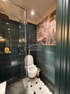 Savremeno opremljeno kupatilo sa tamnozelenim pločicama i tuš kabinom. - image 9