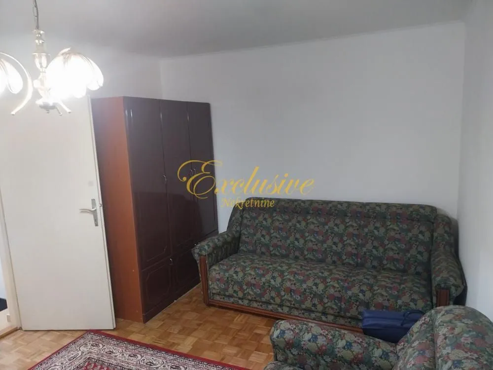Dnevna soba sa garniturom za sedenje i ormarom.