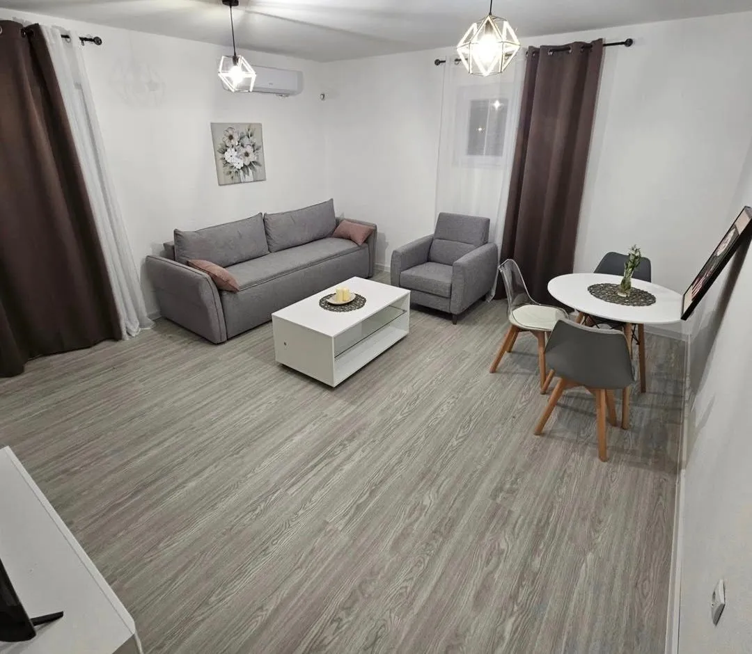 Spacious living room with a sofa, coffee table, and dining table.