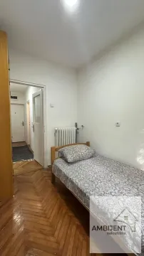 Manja spavaća soba sa jednim krevetom i parketom na podu. - image 7