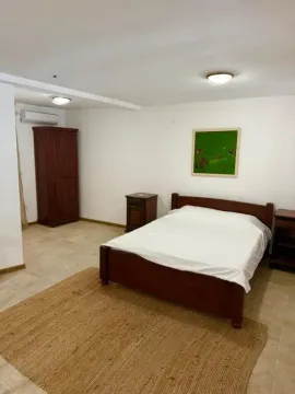 Bedroom with a double bed, wooden wardrobe, and bedside tables. - image 17