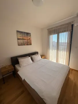 Spavaća soba sa bračnim krevetom, noćnim ormarićima i izlazom na terasu. - image 3