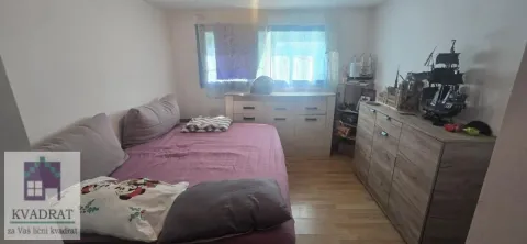 Manja spavaća soba sa krevetom i drvenim komodama. - image 6
