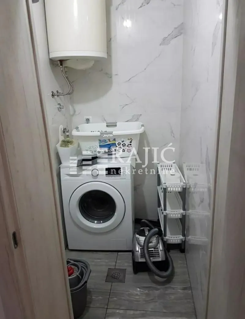 Bathroom with a washing machine and water heater.