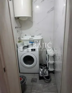 Bathroom with a washing machine and water heater. - image 8