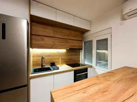 Modern kitchen with wooden elements and built-in appliances. - image 5