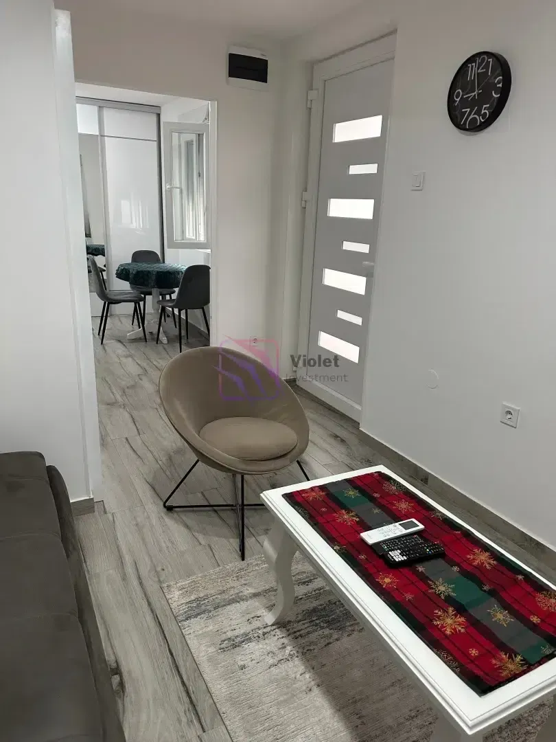 Living room with a sofa, coffee table, and a view of the hallway and dining area.