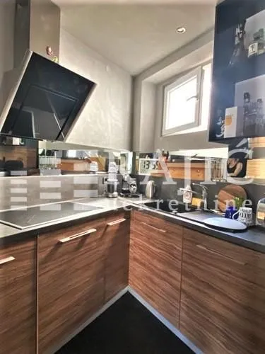 Modern kitchen with wooden cabinetry and built-in appliances.