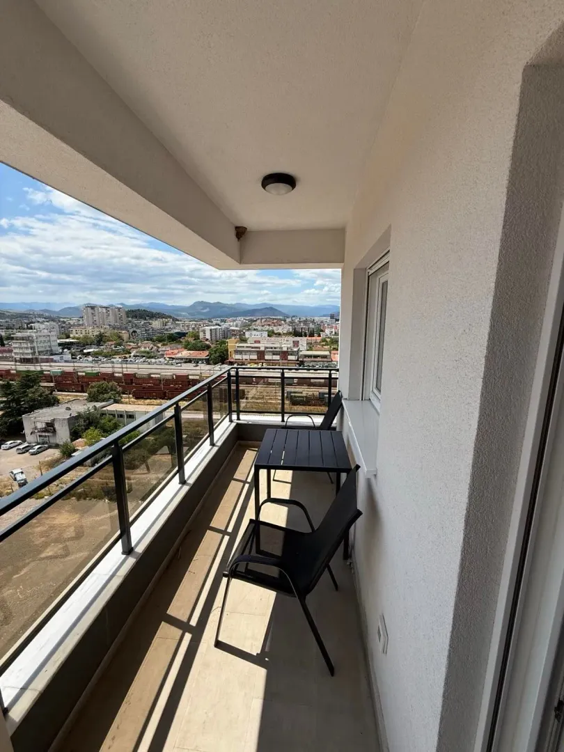 Natkriveni balkon sa garniturom za sjedenje i pogledom na grad.