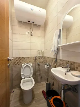 Small bathroom with a toilet, washbasin, mirror and a water heater on the wall. - image 7