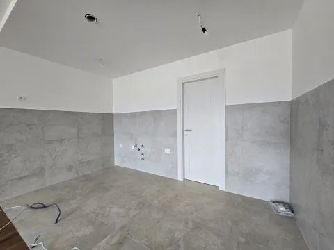 Empty room with grey tiles and prepared connections for a kitchen. - image 5