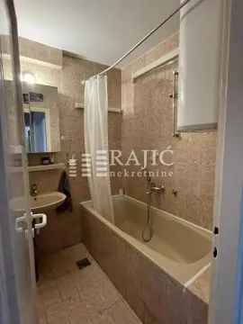 Small bathroom with a tiled bathtub and shower curtain. - image 6