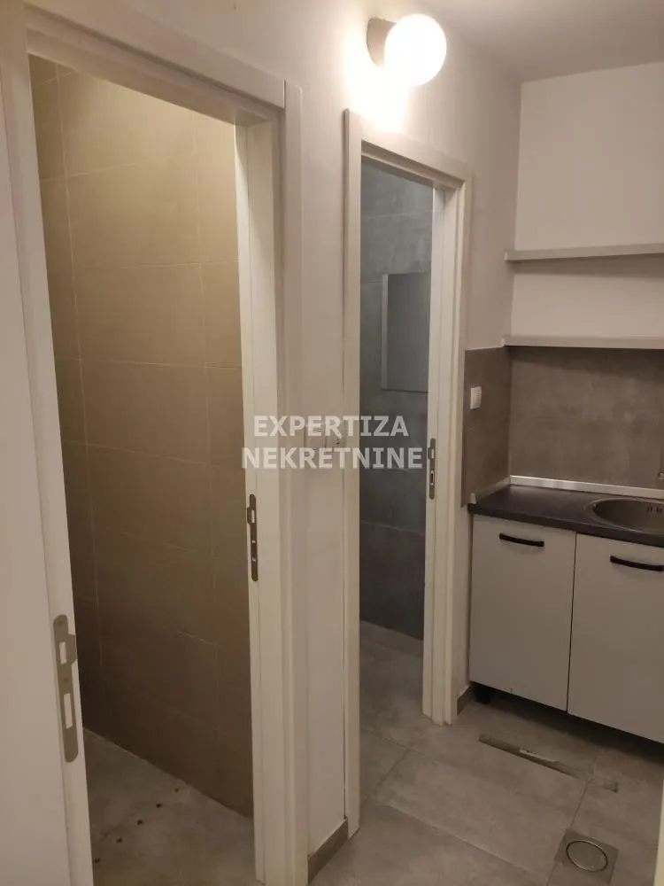 Smaller kitchen with cabinetry and an open passage leading inside the apartment.