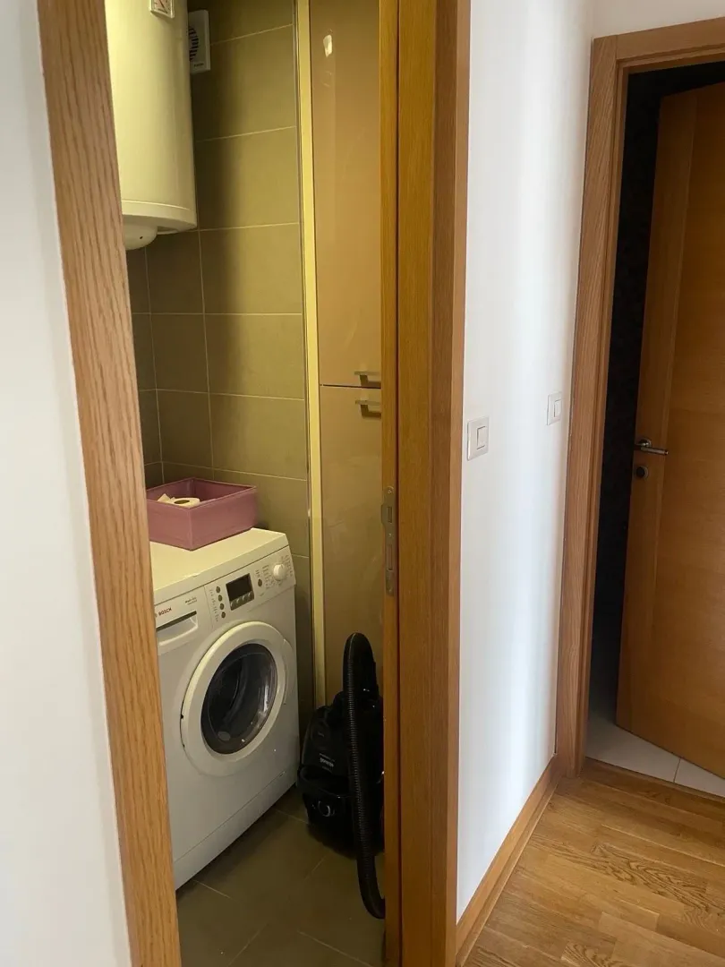 Small bathroom with a washing machine and built-in cabinet.