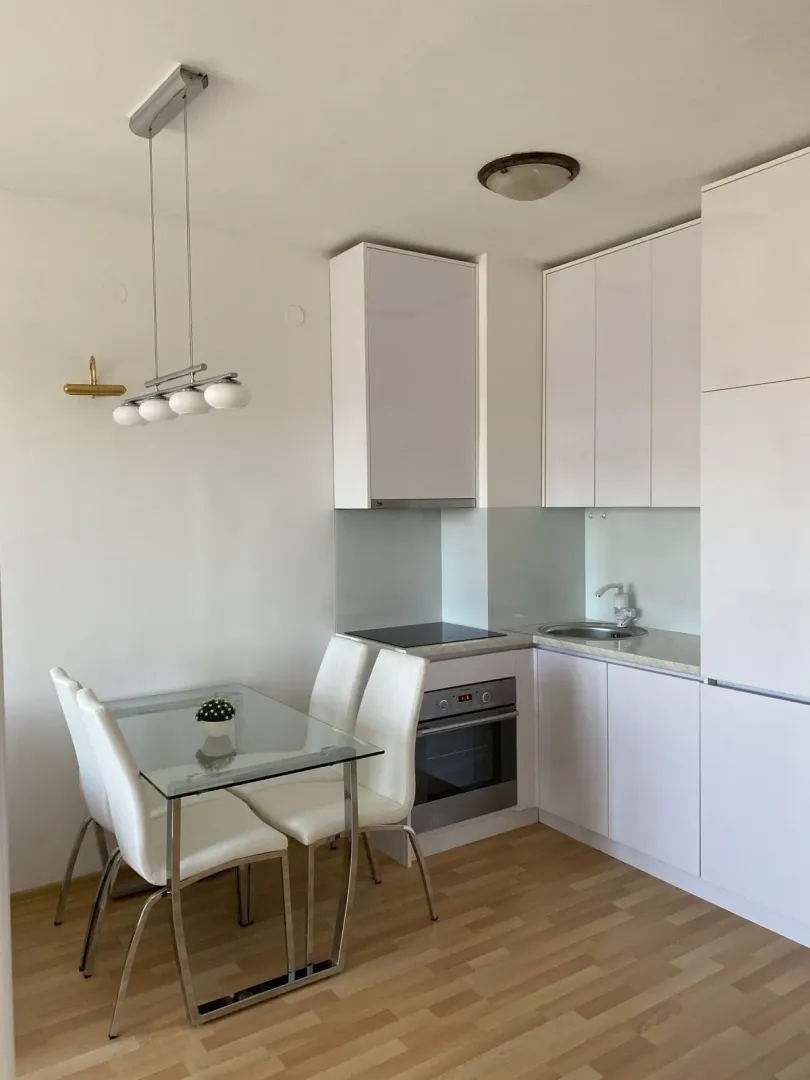 Bright kitchen with a small dining area and white cabinets.