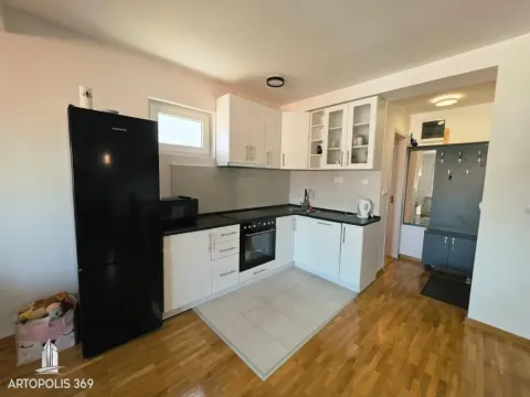 Small kitchen with white cabinets and a black refrigerator. - image 10