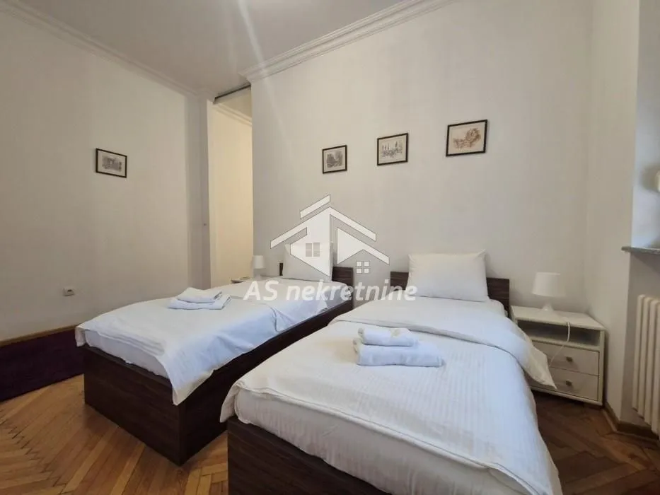 Bedroom with two single beds and white linens.
