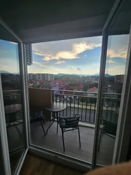 Namješten balkon sa stolom i stolicama i pogledom na grad. - image 7