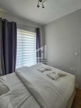 Spavaća soba sa bračnim krevetom i prozorom sa zavjesama. - image 7