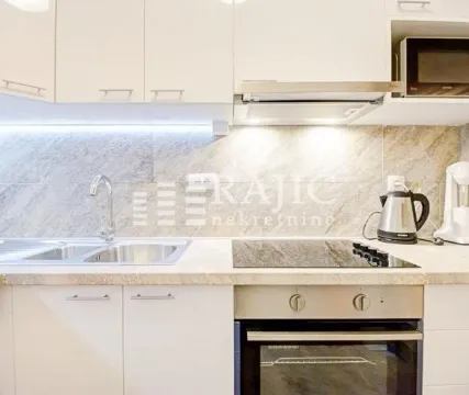 Modern kitchen with white cabinets, built-in oven and cooktop. - image 8