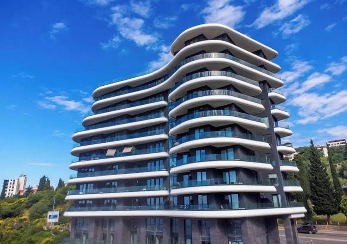 Exterior of a modern multi-story residential building with terraces.