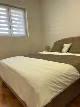 Furnished bedroom with a double bed and a window. - image 11